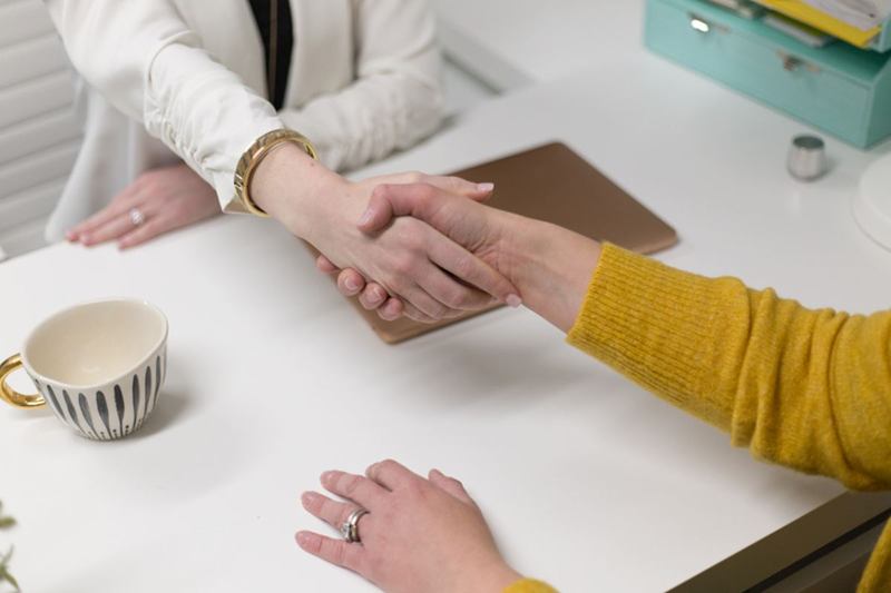 Handshake at a desk symbolising a handover guarantee