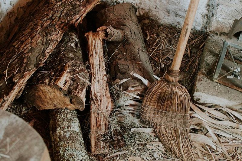 Old broom leaning against logs, swept clean is not fully cleaned