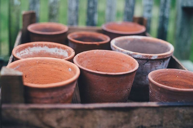 Macetas de terracota vacías con marcas de cal en una caja de madera