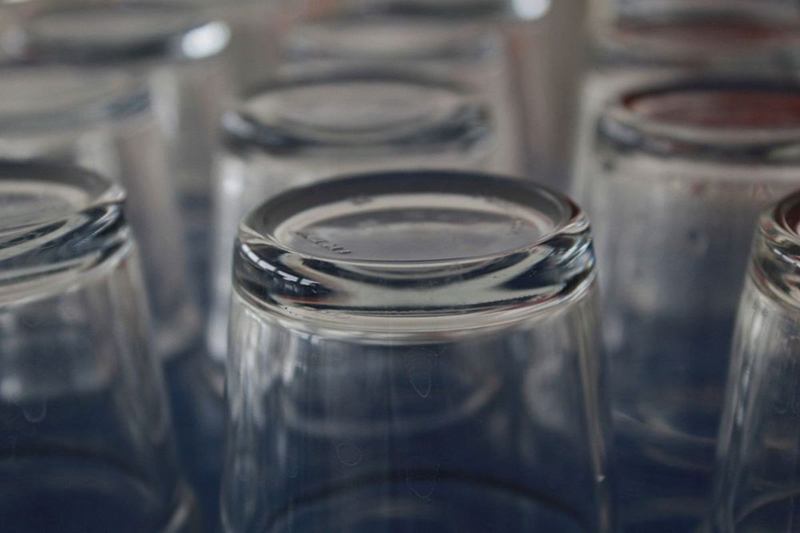 Vasos relucientes sin marcas boca abajo sobre una superficie oscura