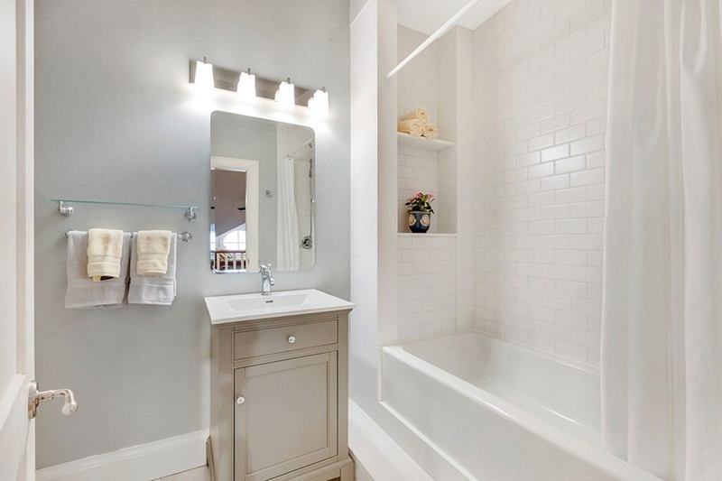 Helles Badezimmer mit weissem Duschvorhang an der Badewanne