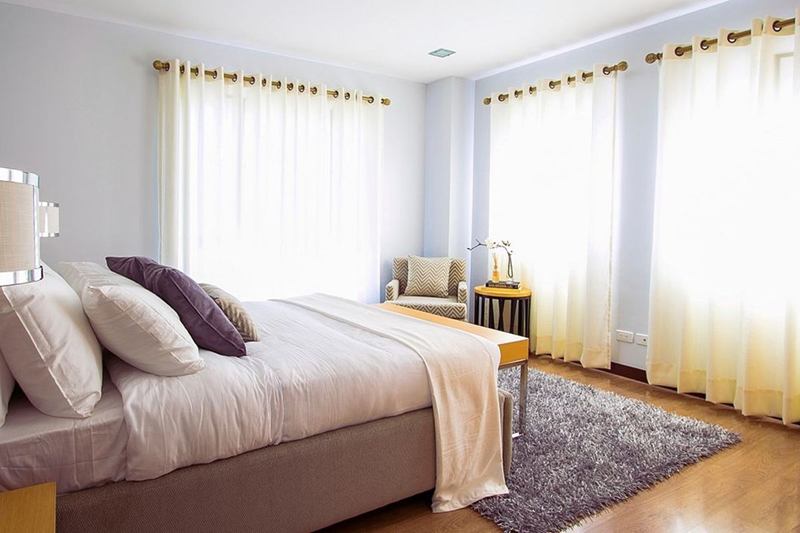 Dormitorio luminoso con alfombra de pelo largo sobre parquet, recién aspirado