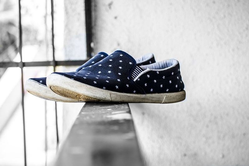 Zapatillas de lona azul con estrellas en un alféizar, plantillas a la vista