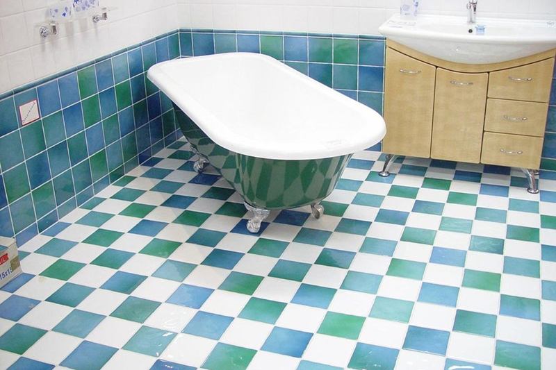Bathroom with blue and green tiles, light grout and a freestanding bathtub, cleaning grout