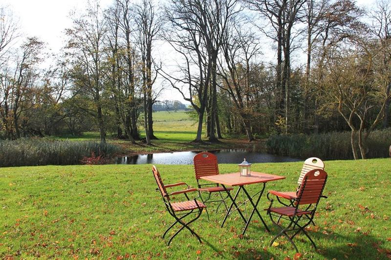 Wooden and metal garden table with chairs on a lawn