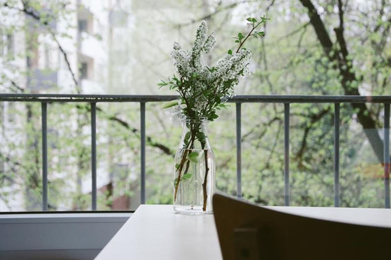 Vase of flowers by an open balcony door to remove odours at home