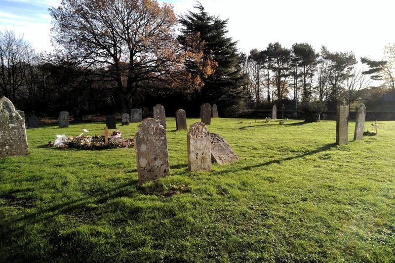 Lápidas antiguas y desgastadas en un cementerio, con musgo y líquenes en la piedra