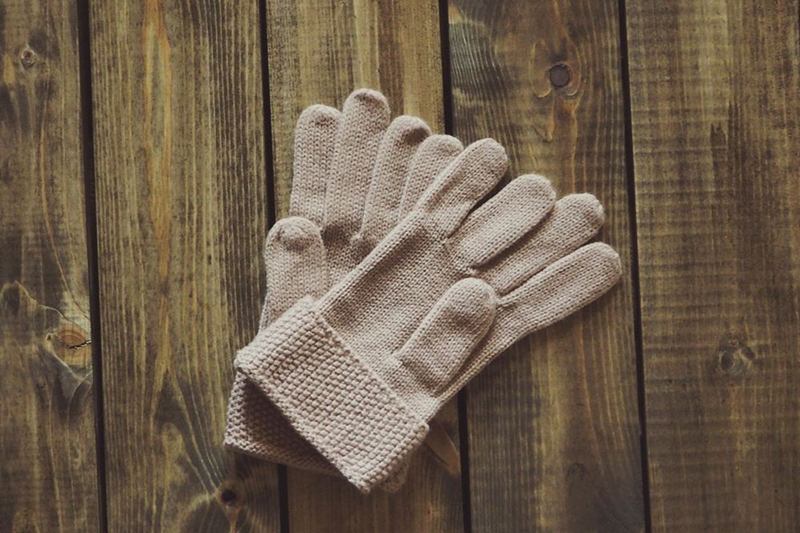 Guantes de lana beige sobre madera, listos para un lavado suave