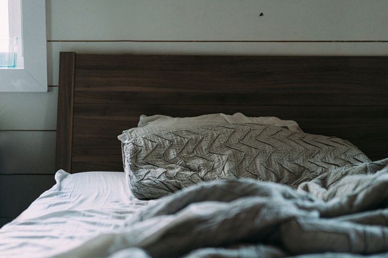 Manta gris arrugada sobre una cama, antes de lavar una manta eléctrica