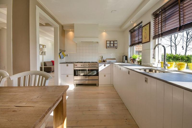 Cocina luminosa con superficie de madera en primer plano que conviene limpiar y aceitar