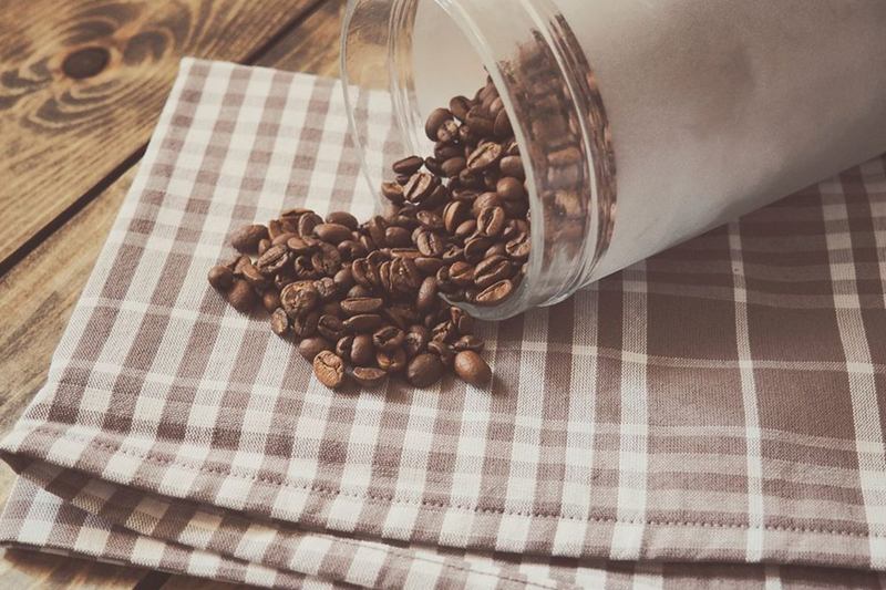 Coffee beans on a checked tea towel, removing coffee stains