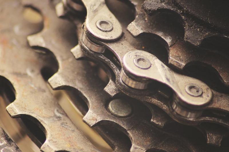 Cadena de bicicleta engrasada sobre el piñón en primer plano, origen de manchas