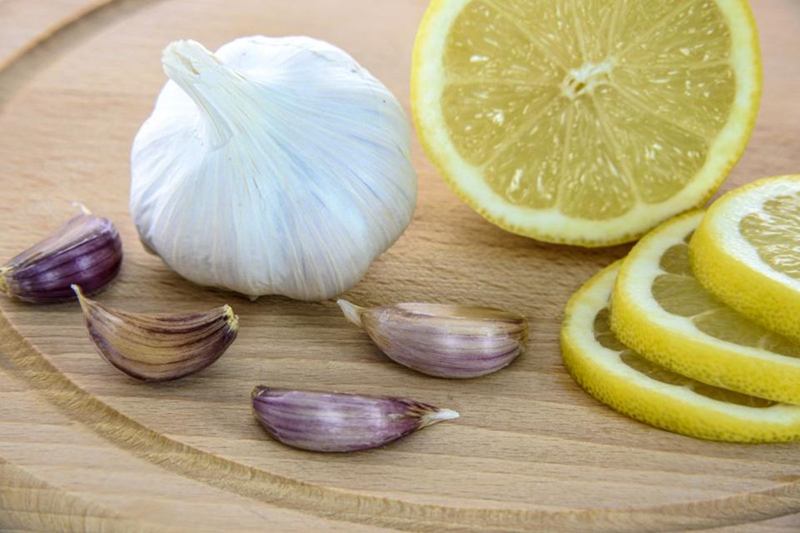 Ajo y limón sobre una tabla, contra el olor a ajo en las manos