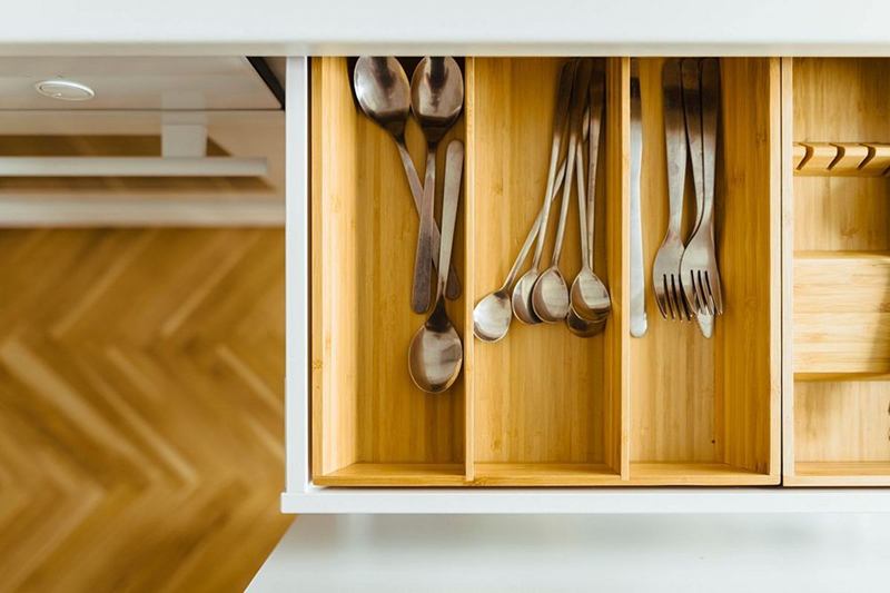 Cajón abierto con cubertero de madera: limpiar los cajones de la cocina con regularidad