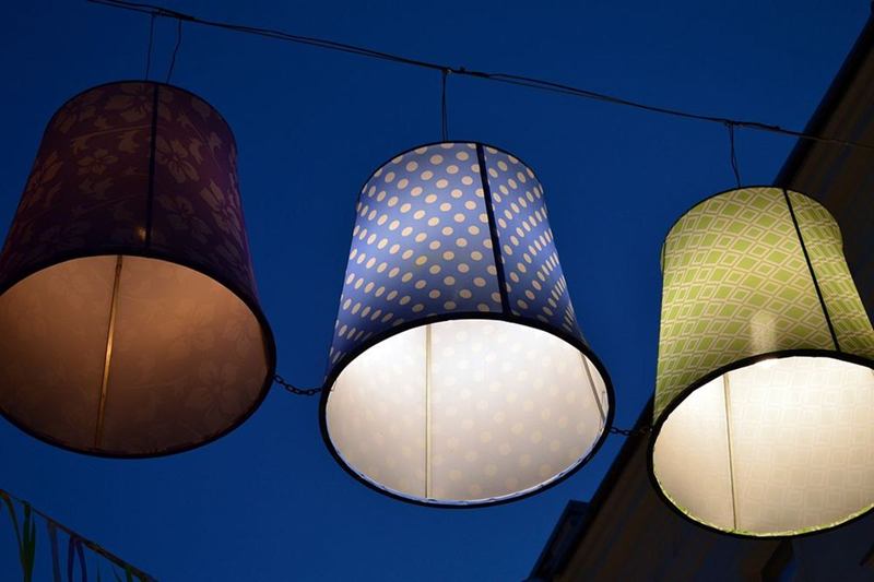 Tres pantallas de tela estampada colgadas y encendidas en el cielo del atardecer