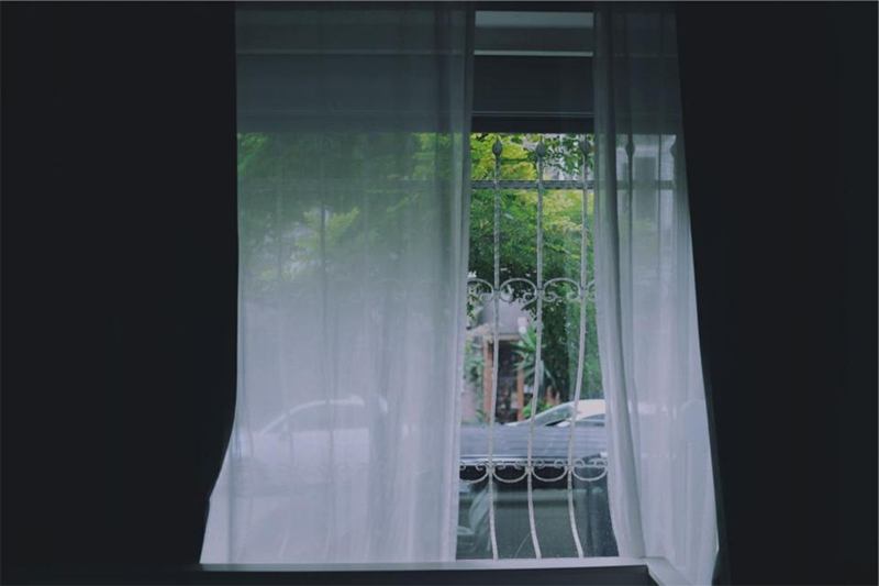 Open window with white curtains for airing the home in hot weather