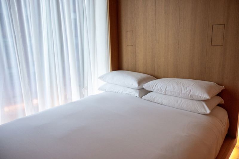 Freshly made bed with white pillows after mattress cleaning