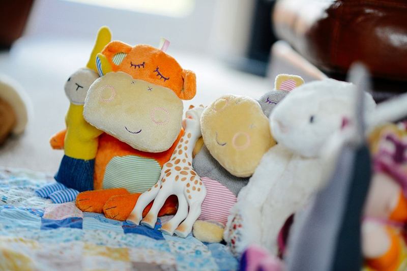 Peluches de colores sobre una manta infantil, listos antes de lavar peluches