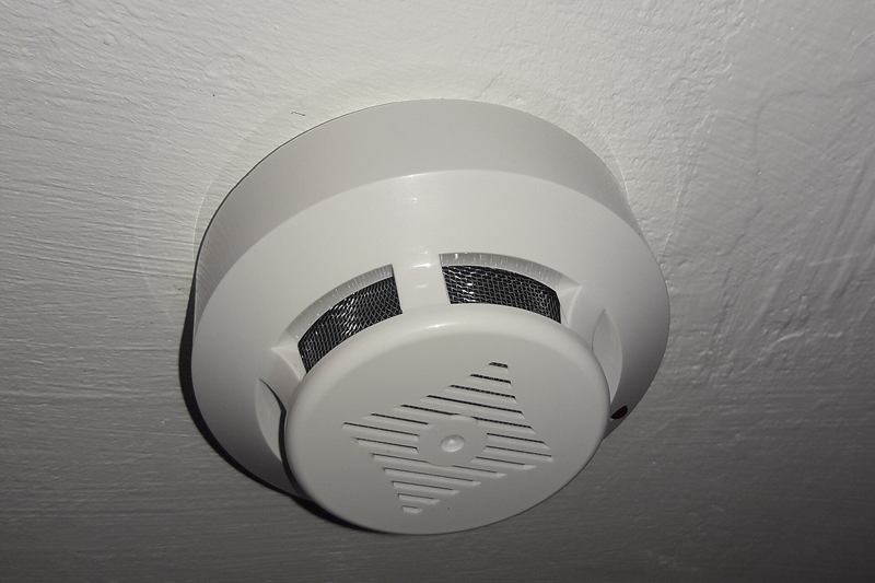 Detector de humo blanco en un techo claro, que conviene limpiar y probar con regularidad