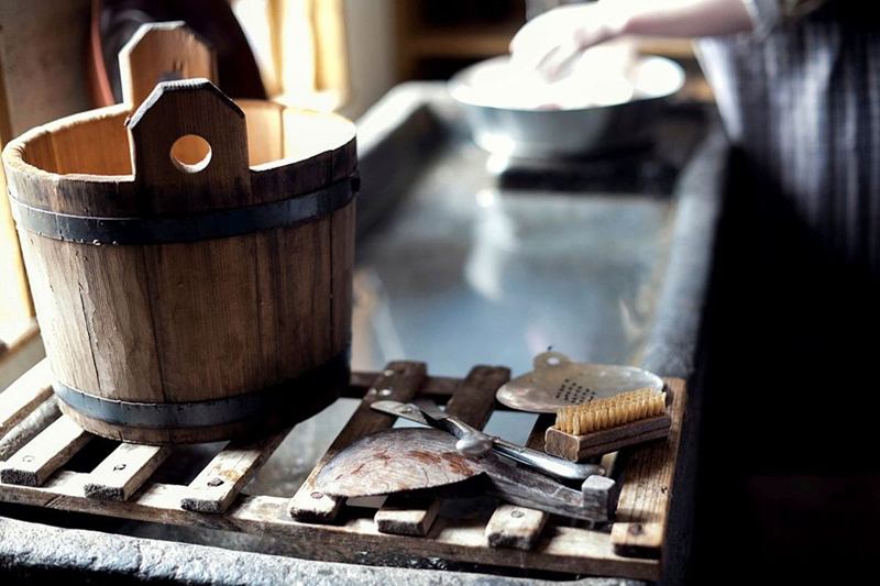Wooden bucket, brush and cleaning tools on a slatted rack