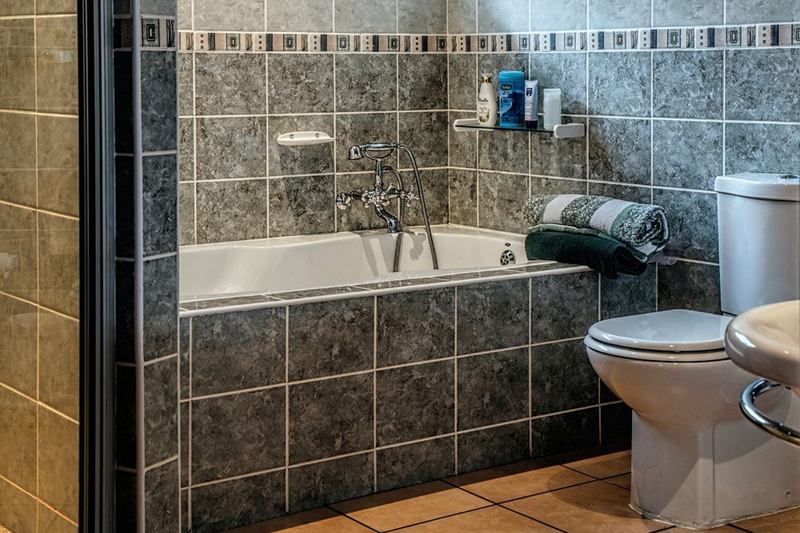 Bañera empotrada entre azulejos, con juntas de silicona que se desgastan