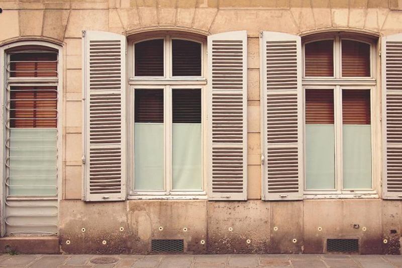 Building facade with light window shutters and blinds