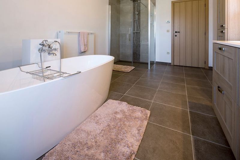 Baño luminoso con bañera exenta y suelo seco, sin milpiés en casa
