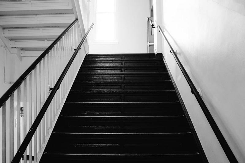 Clean stairwell with white railing and dark steps