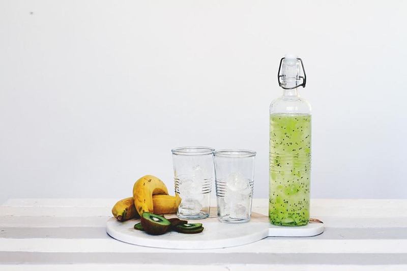 Glass drinking bottle with swing top, glasses and bananas