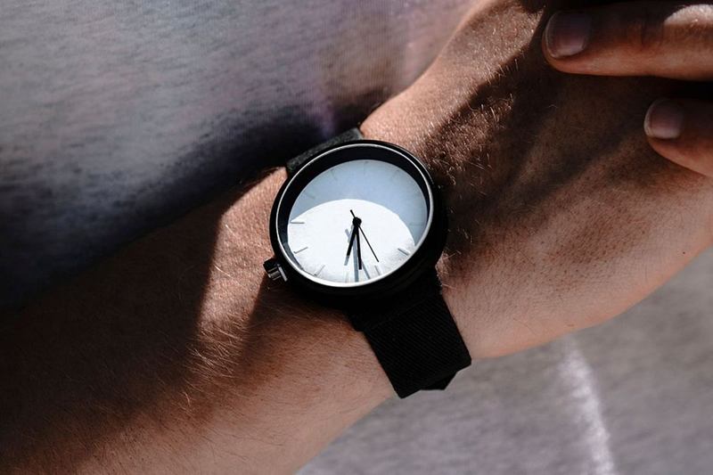 Reloj con correa negra en la muñeca, listo para limpiar