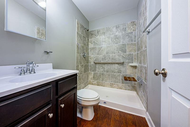 Bright bathroom with toilet, basin and shower, free of limescale