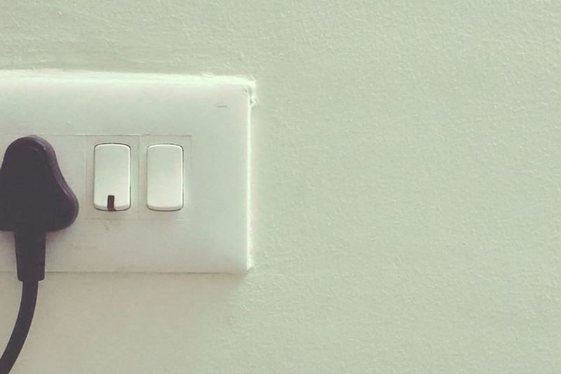 Enchufes e interruptores blancos de plástico en la pared, que amarillean con el tiempo