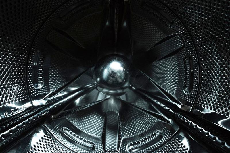 Inside the stainless steel drum of a washing machine, cleaning the washing machine