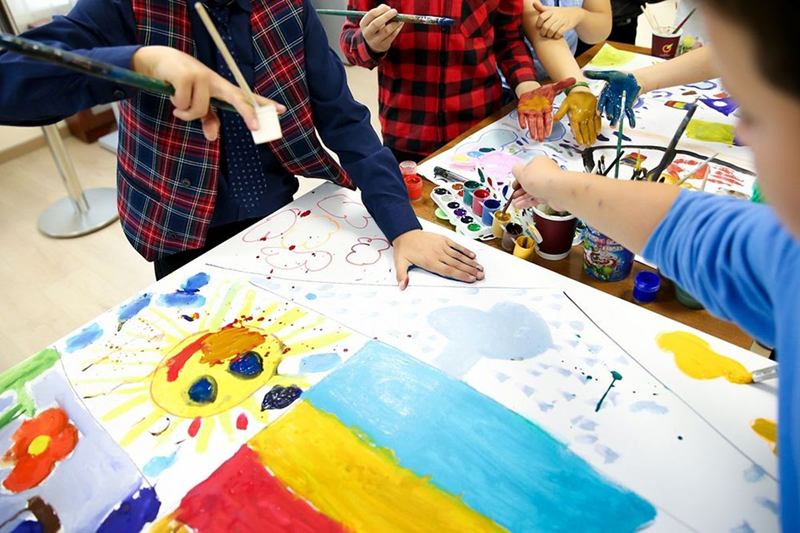 Niños pintando con acuarelas en una mesa donde las manchas aparecen enseguida