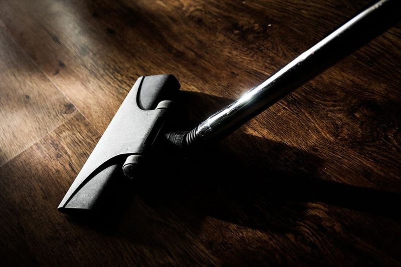 Vacuum cleaner head on a wooden floor for quick apartment cleaning