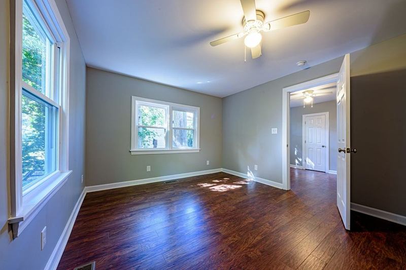 Empty room with wooden floor and open door, ready for handover