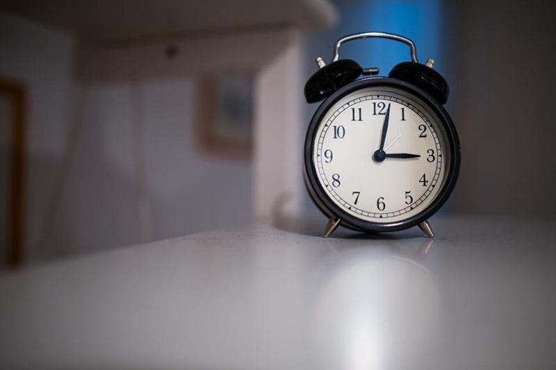 Black alarm clock on a table, apartment handover under time pressure