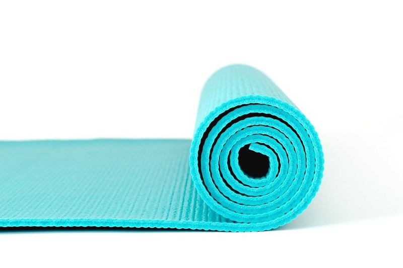 Esterilla de yoga turquesa medio enrollada que se limpia con suavidad